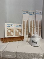 Entire lot: four long applique packs, two corner applique packs, peg rack, honey jar with dipper