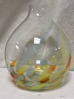 Full front view of clear bulbous vase with colored swirls