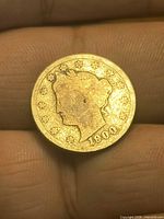 Obverse of 1900 Liberty Head V nickel on fingertip
