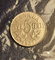 Reverse of 1927 Canadian 5-cent coin showing denomination and maple leaves
