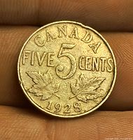 Reverse of 1928 Canada 5-cent coin showing denomination, maple leaves, date