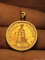 Obverse view of coin pendant showing National War Memorial side