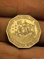 Obverse of 1990 Belize $1 brass coin showing ship design