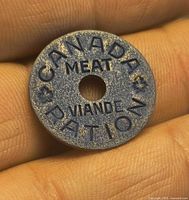 Obverse view of blue Canada meat ration token showing text and central hole