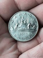 Reverse of 1975 Canadian Voyageur dollar coin in hand
