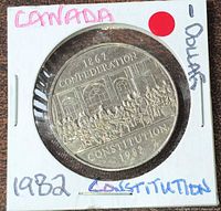 Obverse view of 1982 Canada commemorative dollar in 2×2 holder showing confederation scene and inscriptions