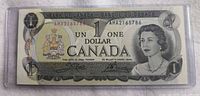 Obverse of 1973 $1 bill showing Queen Elizabeth II, serial AM2165786, in plastic holder