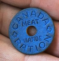 Obverse of blue Canada meat ration token showing CANADA MEAT VIANDE RATION text and maple leaves
