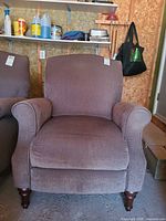 Front view of brown-taupe fabric roll-arm armchair with removable cushion and turned wooden legs