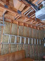 Full view of aluminum extension ladder mounted on wall