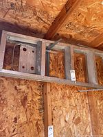 Full view of 6 ft aluminum ladder hung on wall