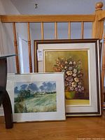 Both framed artworks leaning against railing