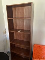 Front view of brown laminate five-shelf bookcase