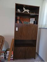 Full view of tall secretary cabinet with shelves, drop-front panel and lower doors
