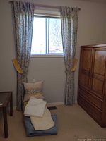 Full view of drapes, tiebacks, pillows and folded linens