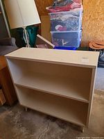 Front view showing two fixed shelves and tapered legs