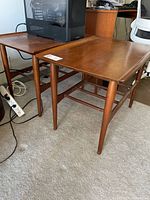 Two square teak veneer end tables side by side