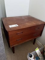 Front and side view of teak two-drawer chest showing overall form and leg style