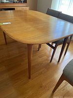 Full view teak oval dining table with extension leaf installed