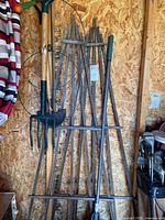 Overall group of tools, trellis panels and supports leaning against wall