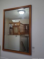 front view of rectangular wood frame mirror on wall