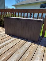Front view of brown resin storage box on deck