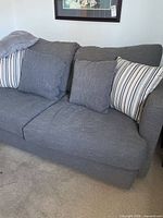 Front view of gray fabric sofa bed with four cushions