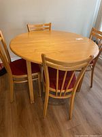 Overall view of round drop-leaf table with four chairs