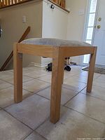 Side view of stool showing wood frame and upholstery