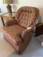 Full view of upholstered swivel armchair beside side table