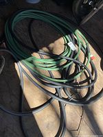 Coiled green vinyl and black rubber hoses together