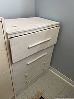 Front view of white painted dresser showing four drawers and overall wear