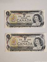 Fronts of both 1973 Canada $1 notes showing Queen Elizabeth II portrait and serial numbers