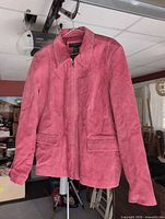 Front view of Geoffrey Beene pink suede jacket on hanger showing style and condition