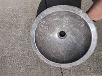 Top view of gray marble vessel sink showing smooth interior and drain opening
