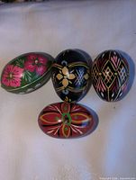 Group shot of four hand-painted wooden eggs