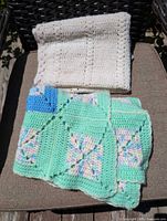 Both folded afghans showing colors and crochet patterns