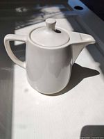 Side view of porcelain coffee pot with lid