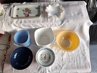 All eight bowls and dishes displayed on cloth