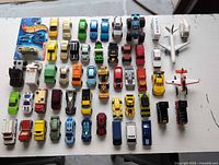 Overhead view showing entire assortment of die-cast vehicles laid out in rows