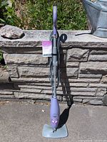 Full view of Shark purple corded steam mop standing upright outdoors