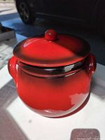 Jar with lid front view showing red glaze and knob
