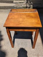 Top view of closed desk showing finish, lift-top seam and pen groove