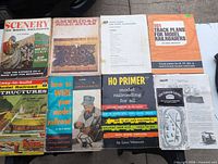 All eight items laid out: six books/booklets and two sheets