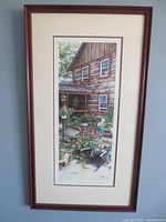 Full view of framed vertical print in wood frame against wall