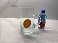 Front view of crystal jug beside Fiji bottle for scale