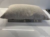 Side view of one beige linen pillow on ruler showing thickness