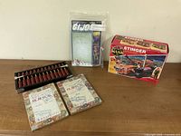 Group shot of boxed Stinger set, bagged G.I. Joe figure, abacus and two workbooks