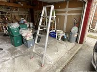 Full view of 6 ft aluminum A-frame ladder standing open in garage