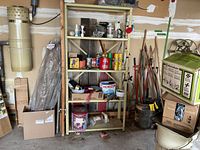 Full view of metal shelving with assorted tools, hardware, aerosol cans